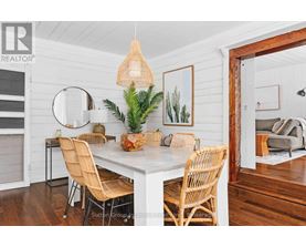 A dining room with a white table and chairs.
