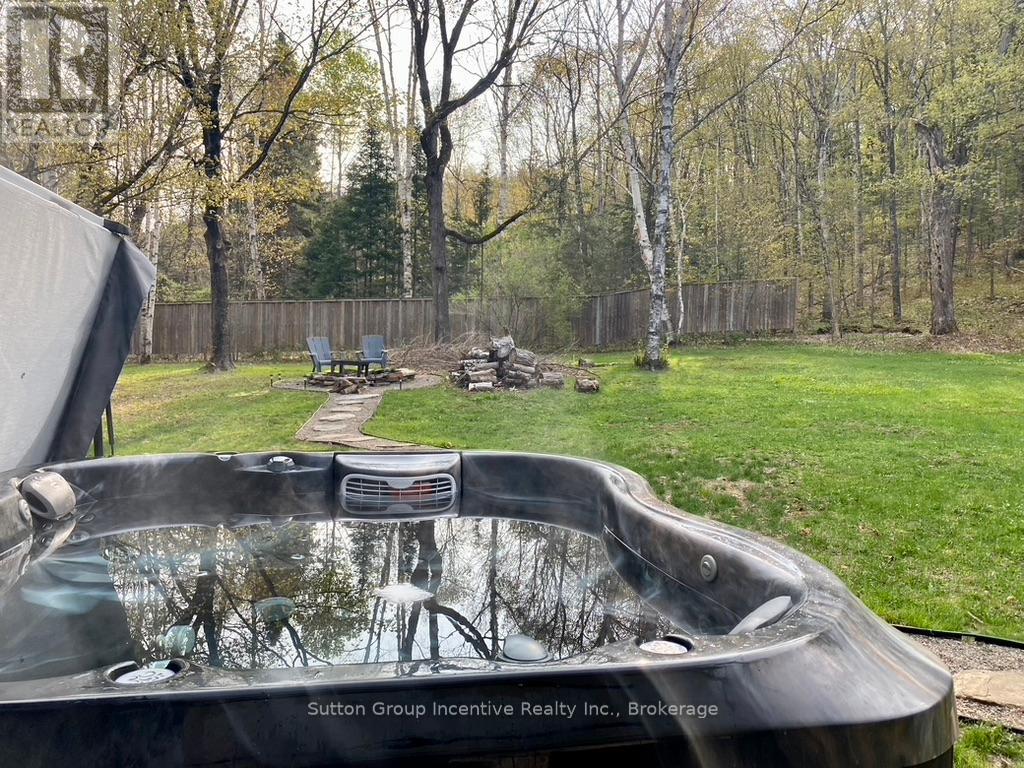 A hot tub sits in the middle of a grassy yard.