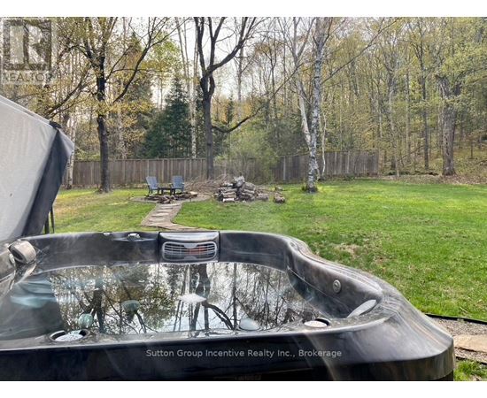 A hot tub sits in the middle of a grassy yard.