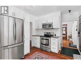 A kitchen with white cabinets and a stainless steel refrigerator.