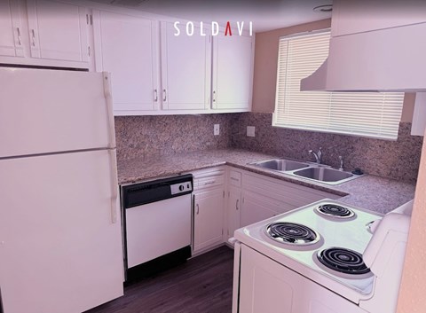 A kitchen with white appliances and cabinets is for sale.