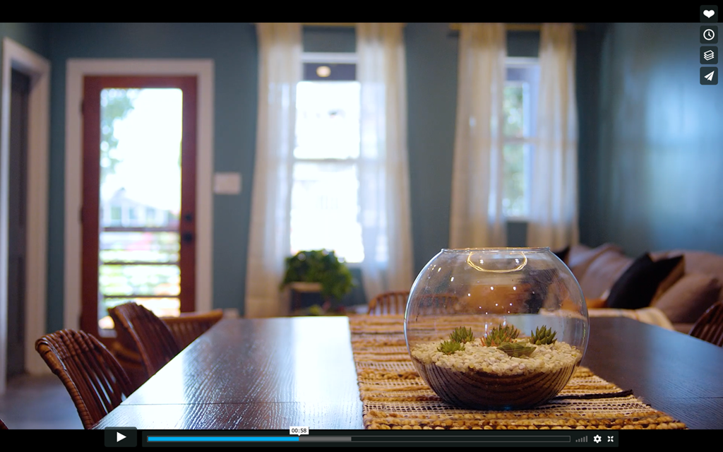 A fishbowl with plants inside is on a table.