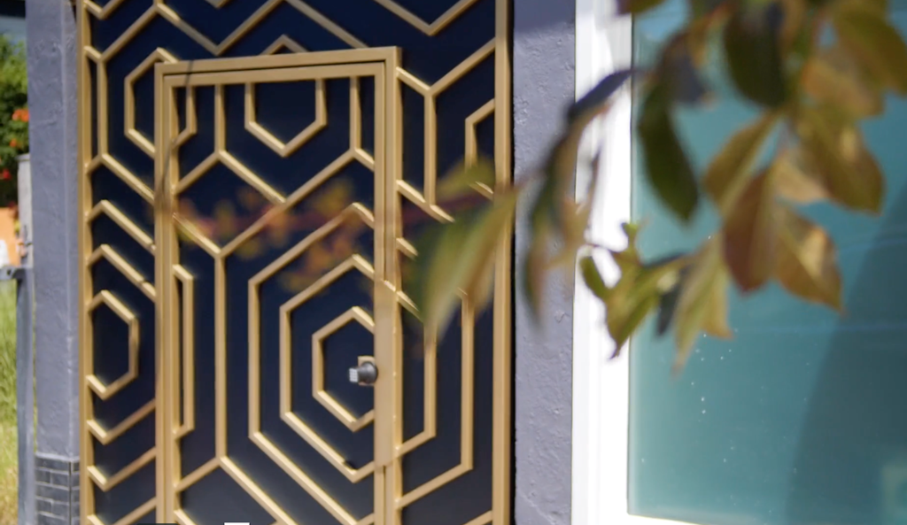 A golden geometric patterned gate with a leaf in the foreground.