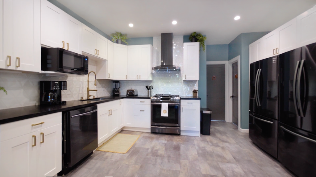 A modern kitchen with black appliances and white cabinets.