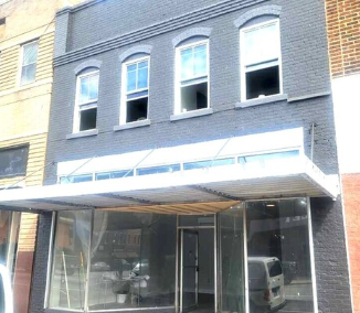A building with a grey facade and a white awning.