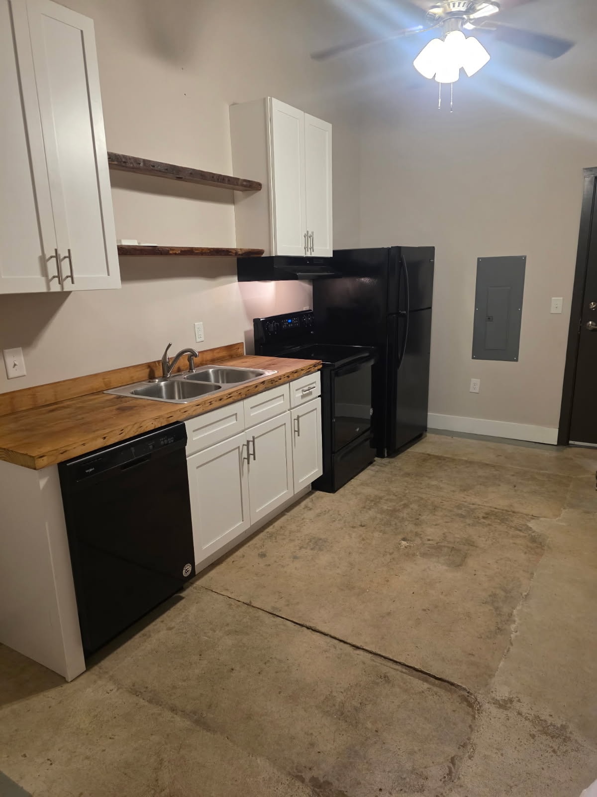 A kitchen with black appliances and white cabinets.
