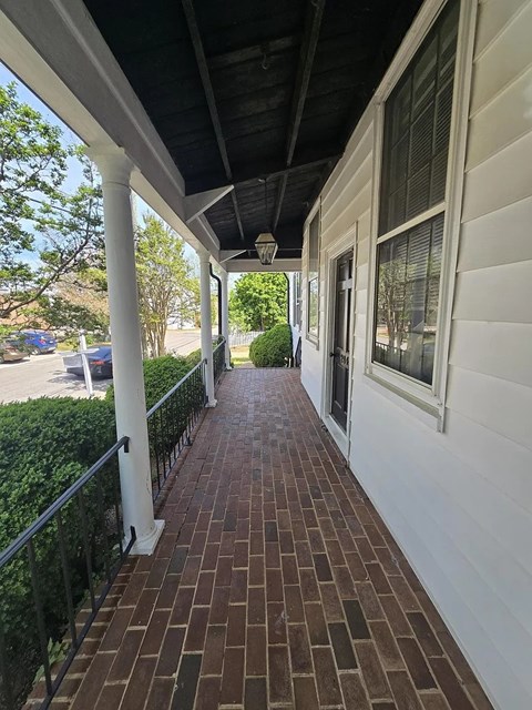 A long brick walkway leads to a white building.