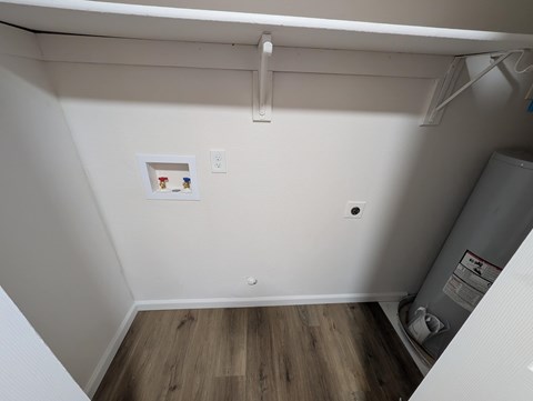 A small room with a white wall and a wood floor.