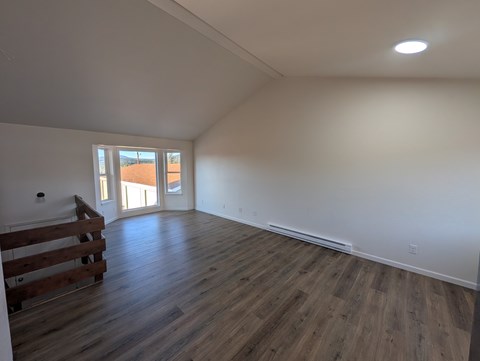 A room with wooden floors and a window.