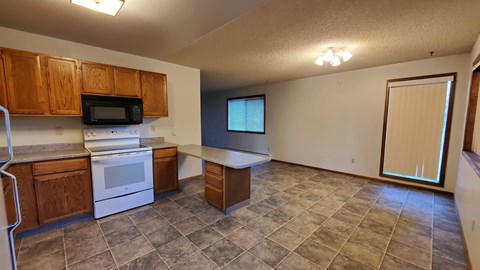A kitchen with a microwave, oven, and refrigerator.