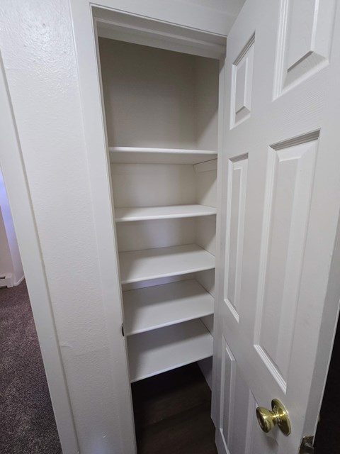 A white door with a shelf underneath it.