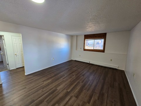 A room with wooden flooring and a window.