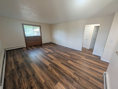 A room with wooden flooring and a window.