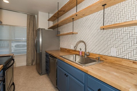 A kitchen with a sink and a refrigerator.