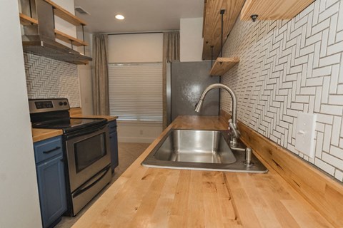 A kitchen with a sink and a stove top oven.