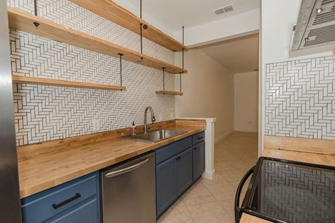A kitchen with a wooden counter top and blue cabinets.