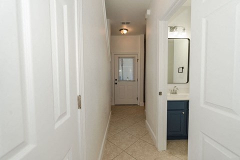 A hallway with white walls and a blue cabinet.