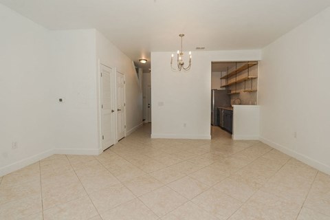 A large empty room with a chandelier and a door.