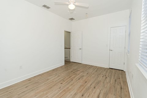 A room with a wooden floor and a ceiling fan.
