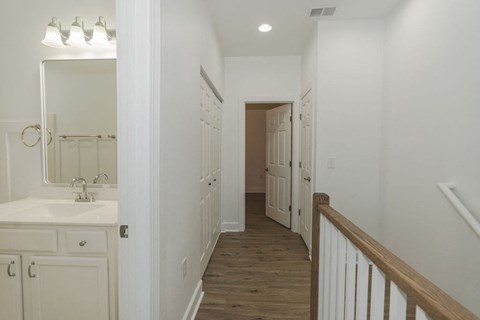 A white bathroom with a wooden floor and white walls.