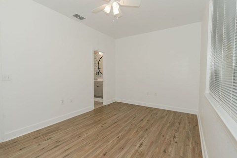 A room with wooden flooring and a ceiling fan.