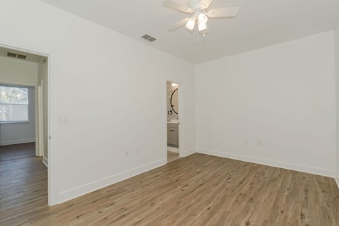 A room with wooden flooring and a ceiling fan.