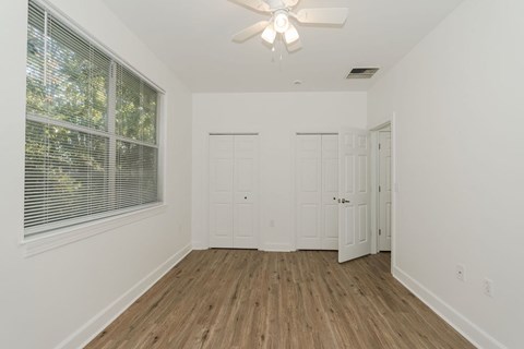 A room with a ceiling fan and two doors.