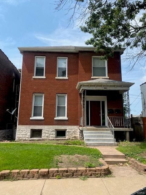 A red brick house with a white door and windows.