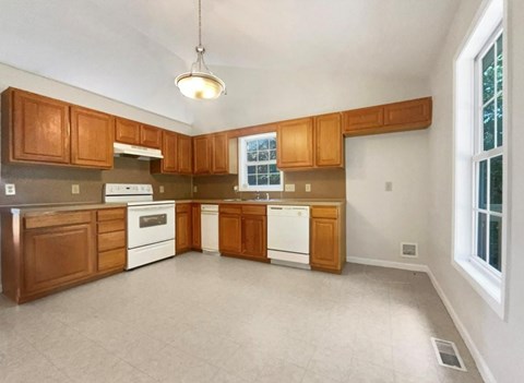 A kitchen with wooden cabinets and white appliances.