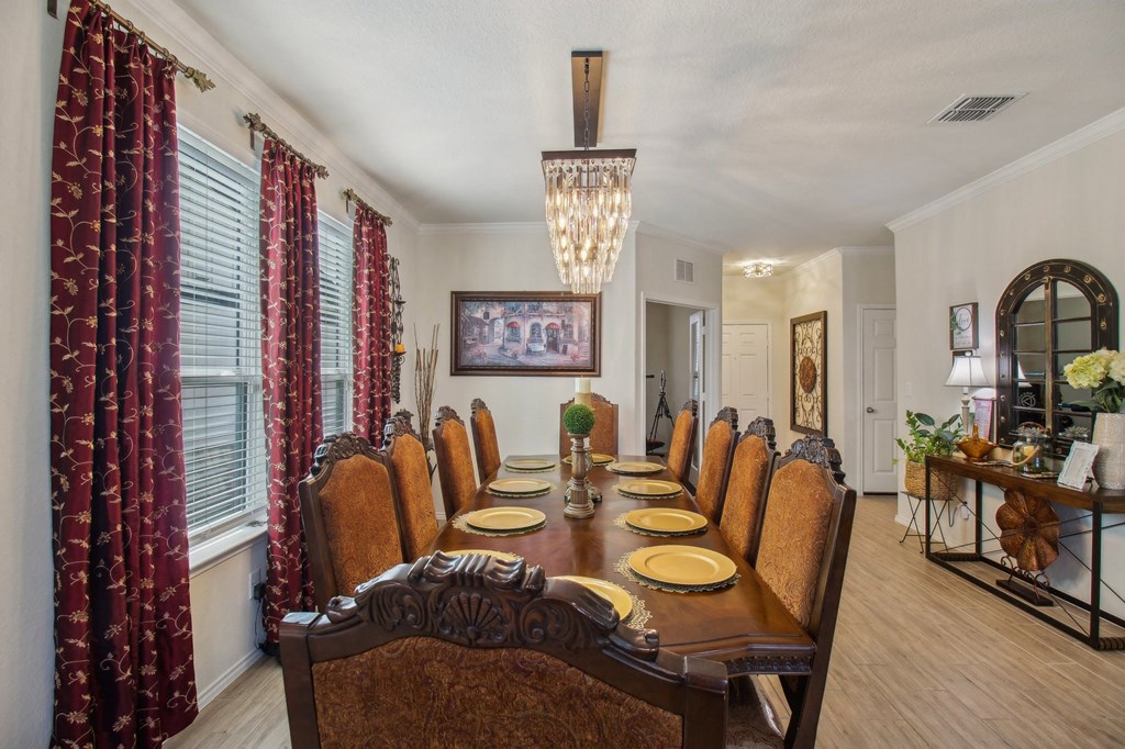 A dining room with a long table set for a meal.
