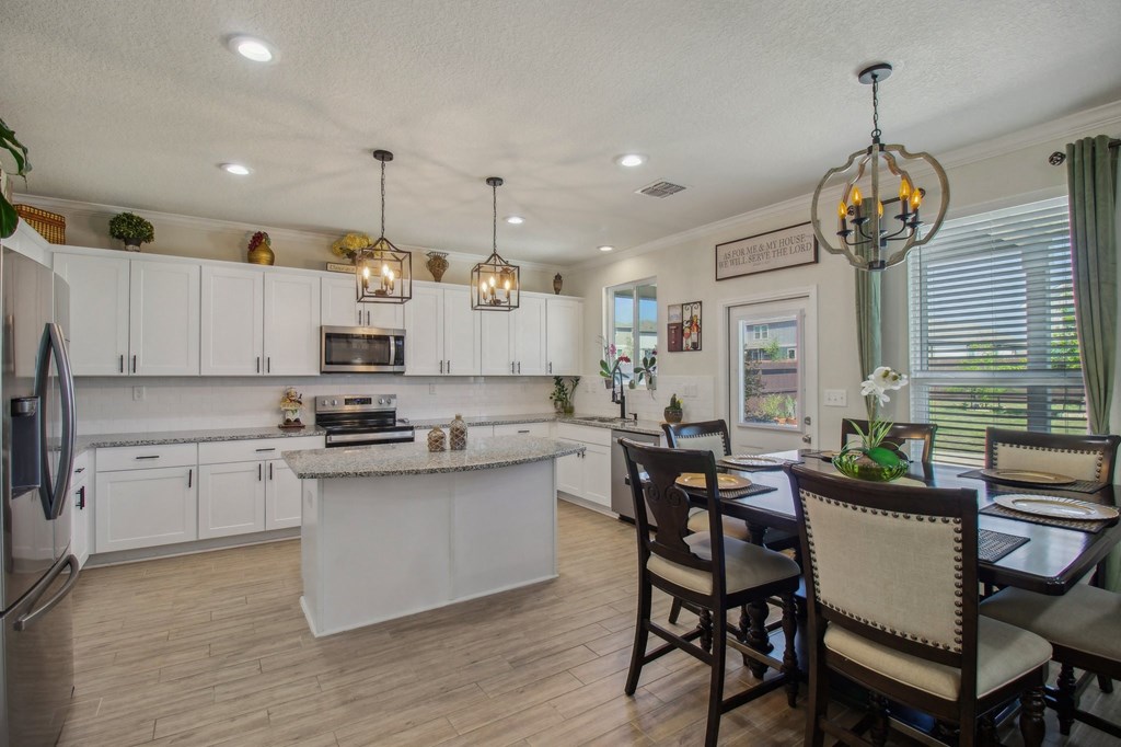 A kitchen with a table and chairs.