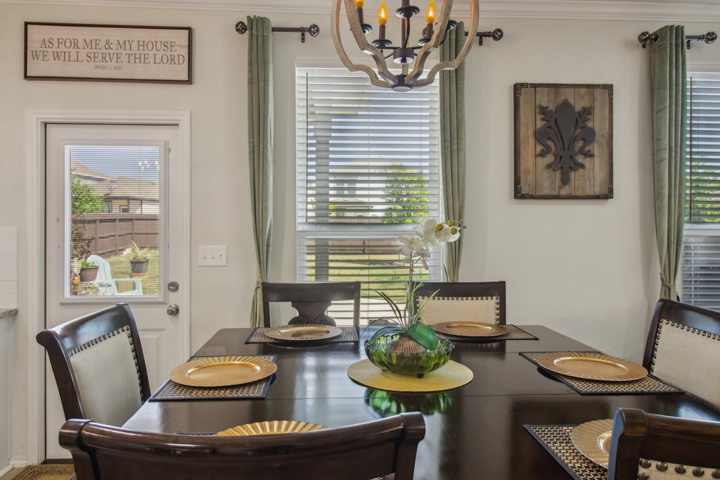 A dining room with a wooden table set for a meal.