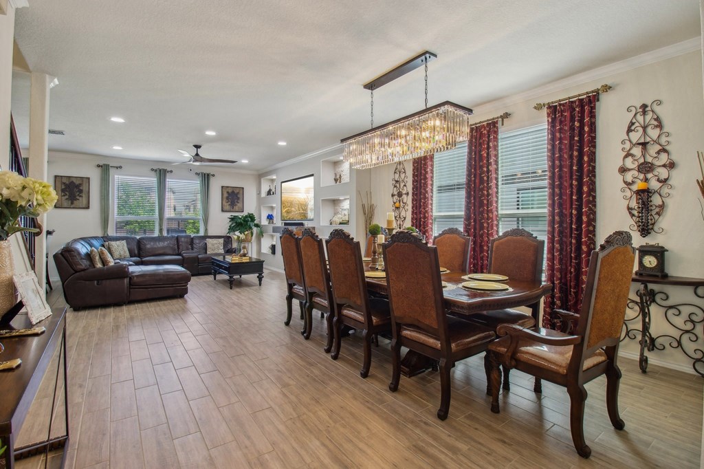 A dining room with a table set for six and a couch in the background.