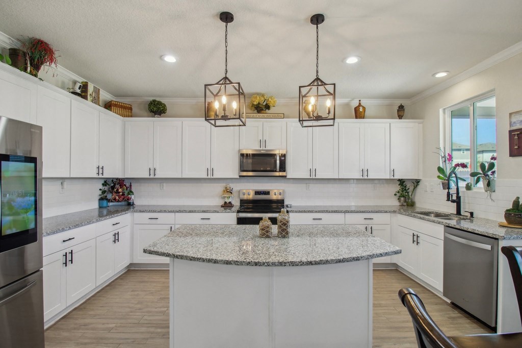 A modern kitchen with a granite countertop and white cabinets.