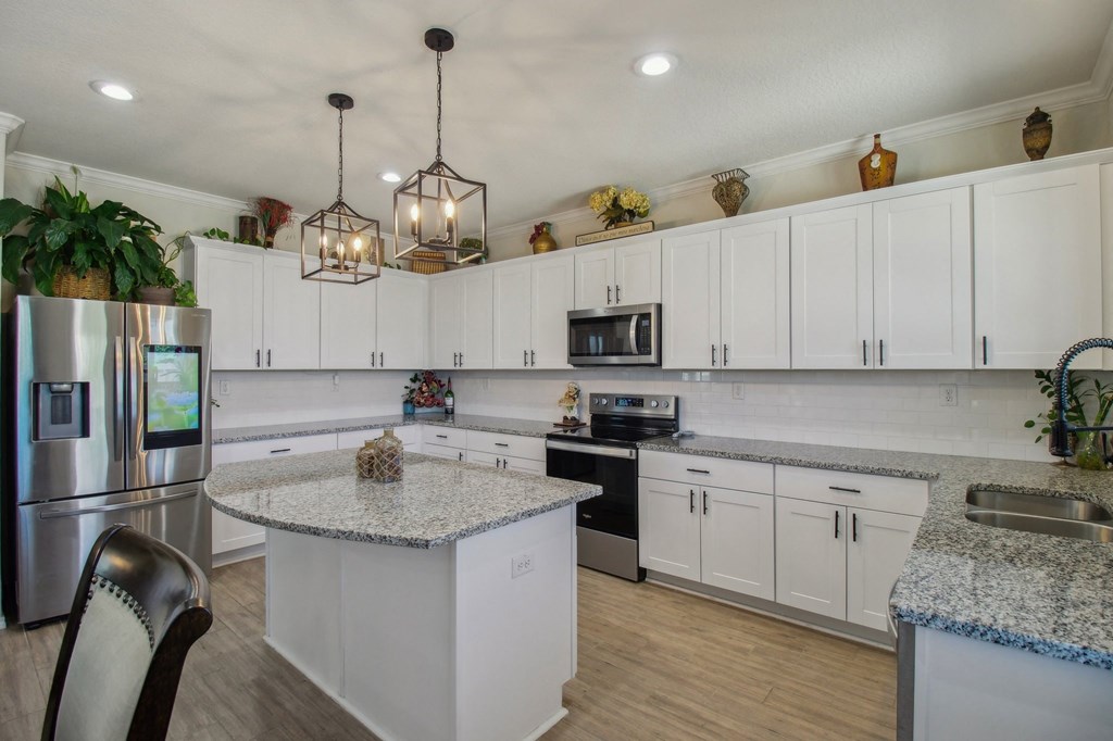 A kitchen with white cabinets and a granite countertop.