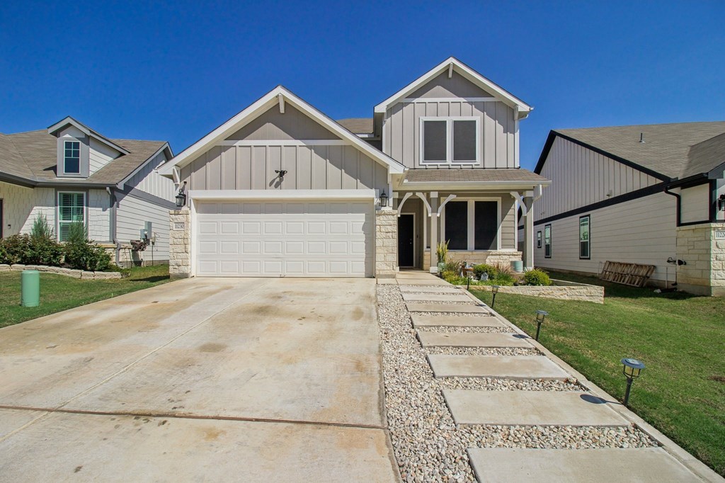 A house with a garage and a driveway in front.