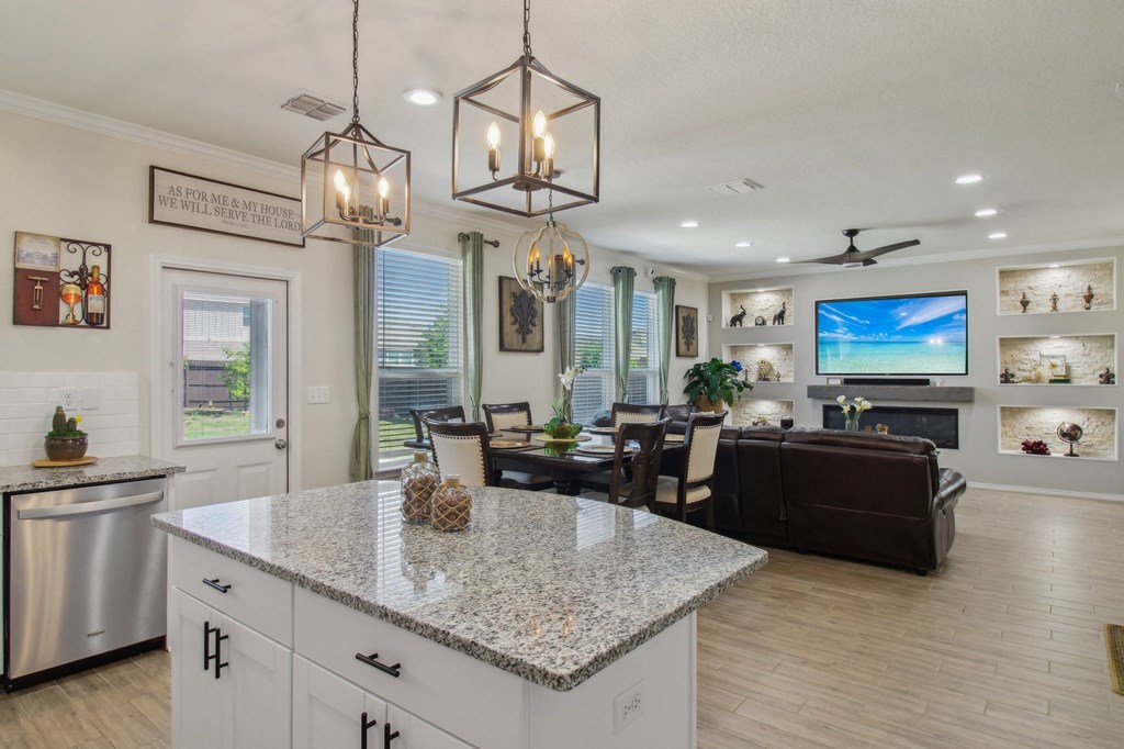 A modern kitchen with a granite countertop and stainless steel appliances.