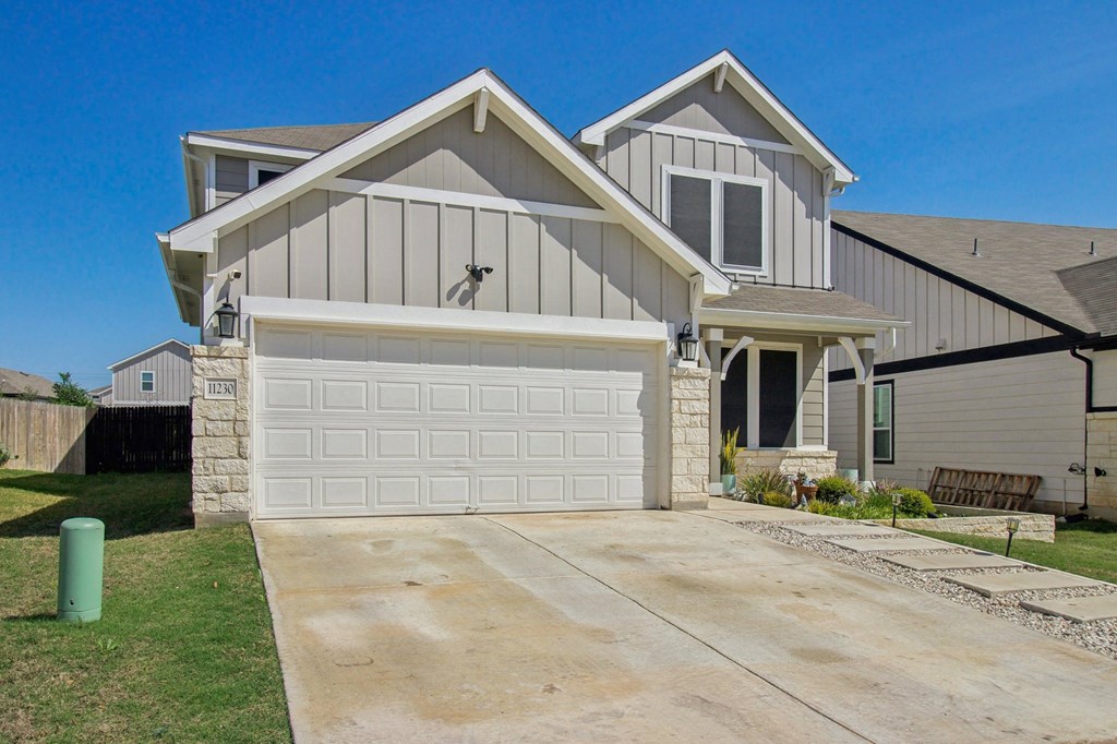A two-story house with a garage and a driveway.