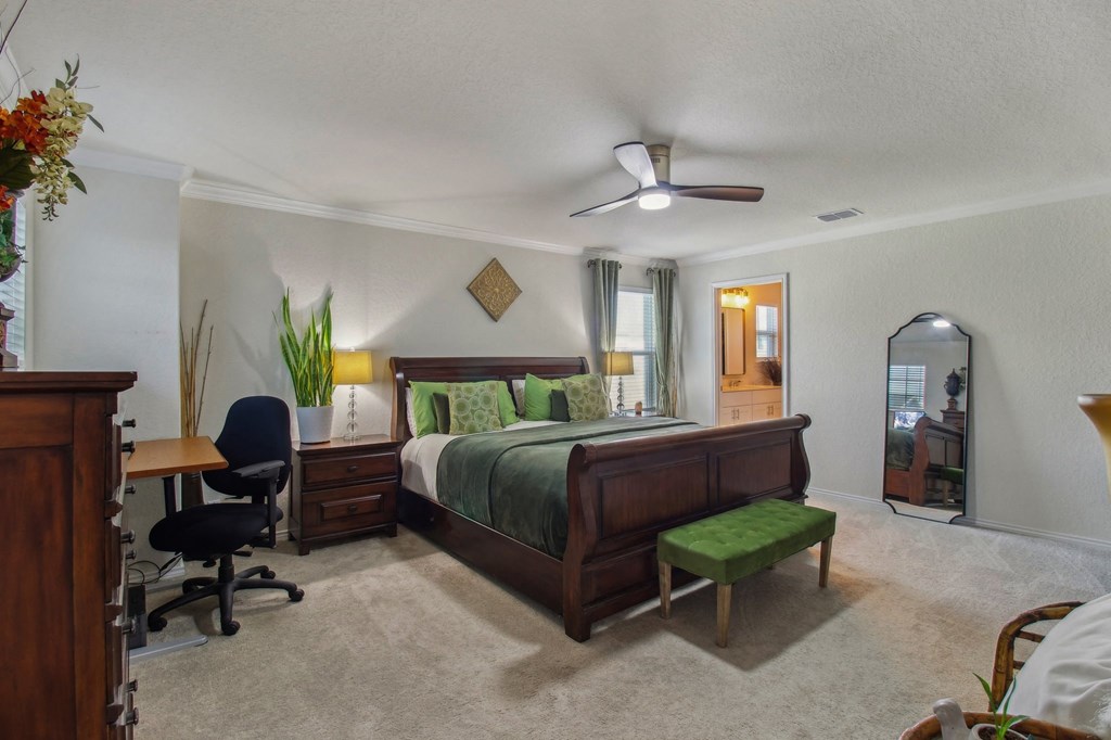 A bedroom with a bed, desk, and chair.