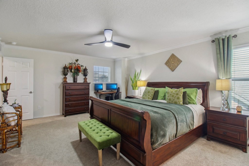 A bedroom with a bed, dresser, and a bench.