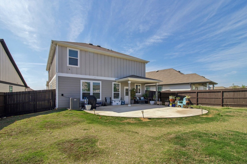 A house with a grey and white exterior and a brown fence.