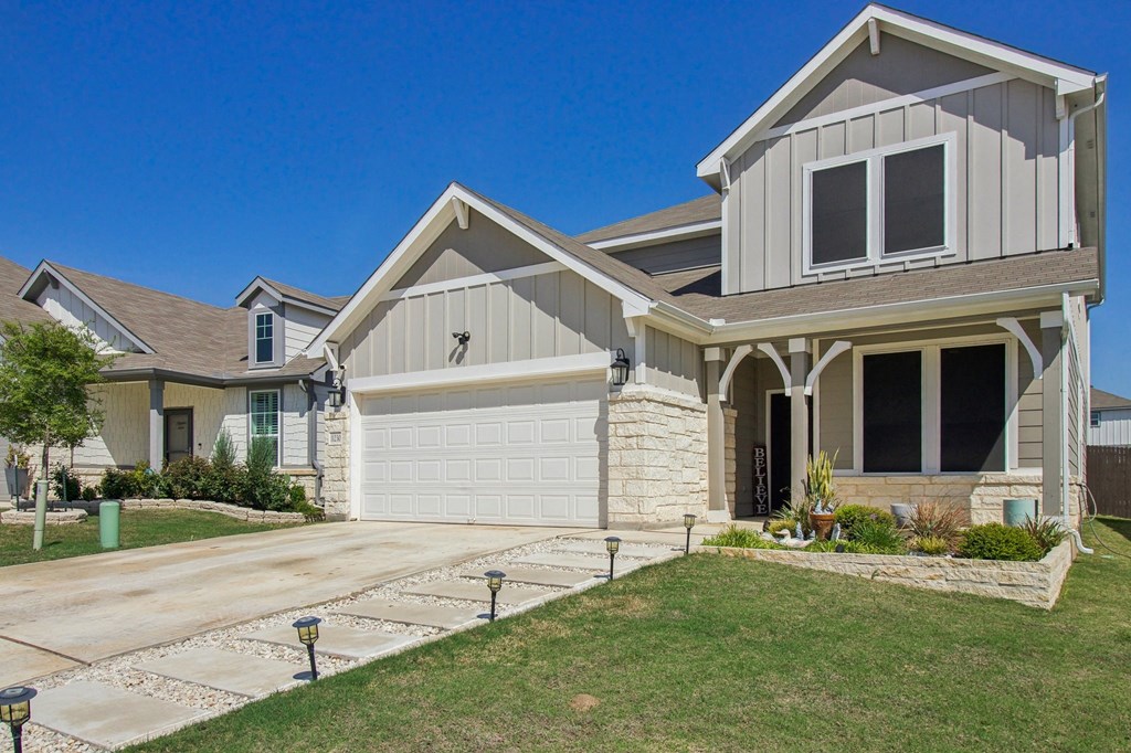 A two-story house with a garage and a driveway.