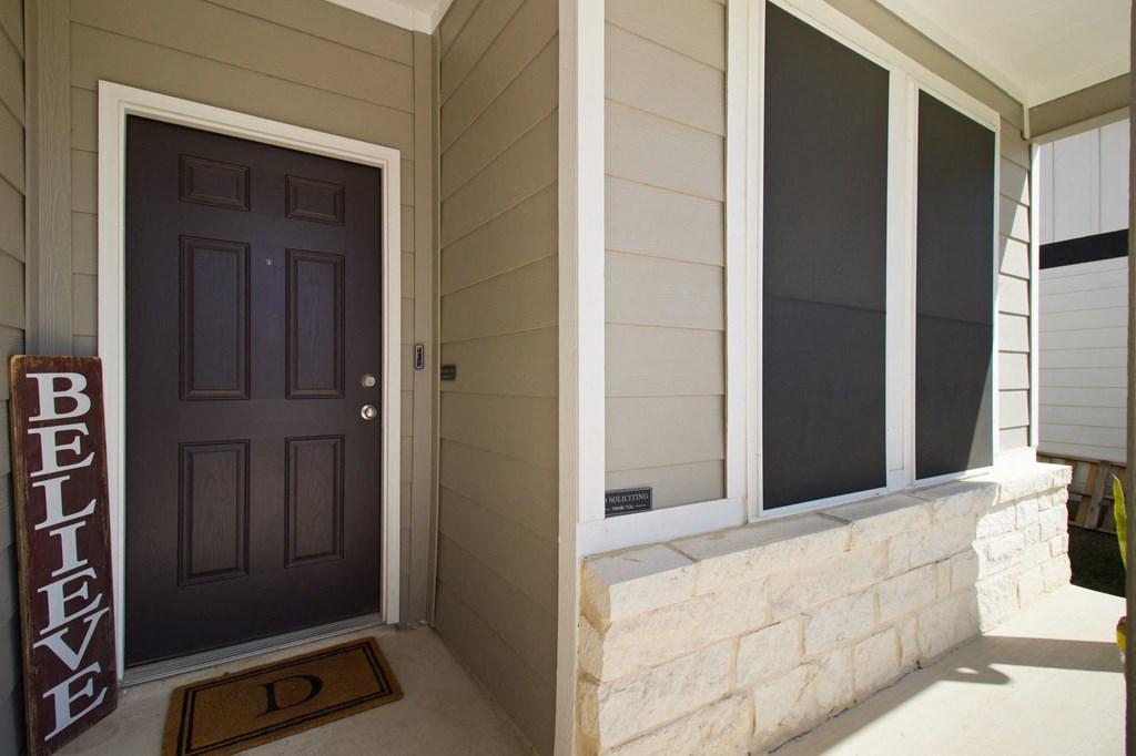 A brown door with a sign that says believe on it.