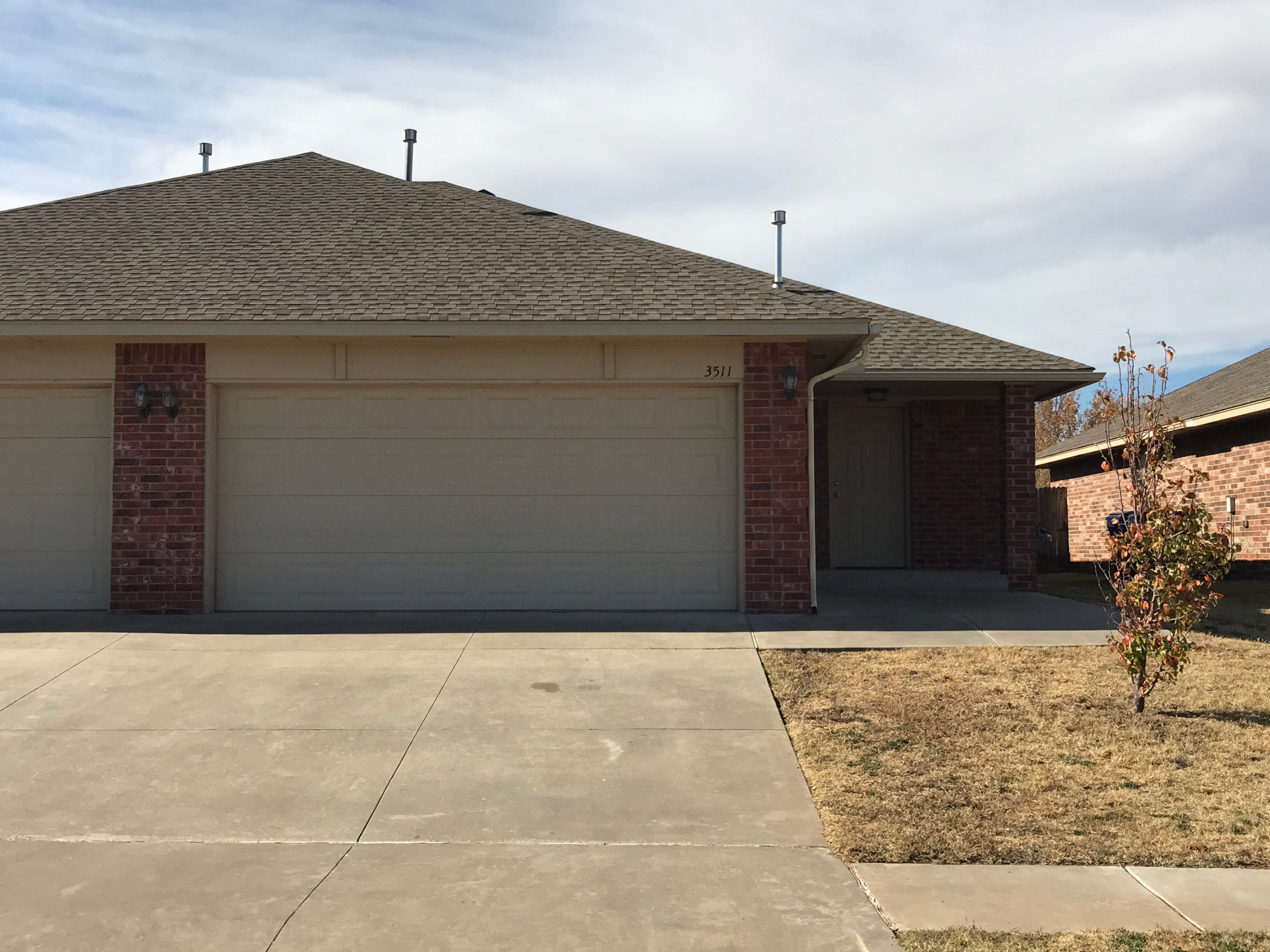 A house with a garage door and a driveway.