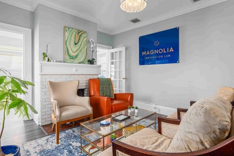 A living room with a couch, chair, and a painting on the wall.