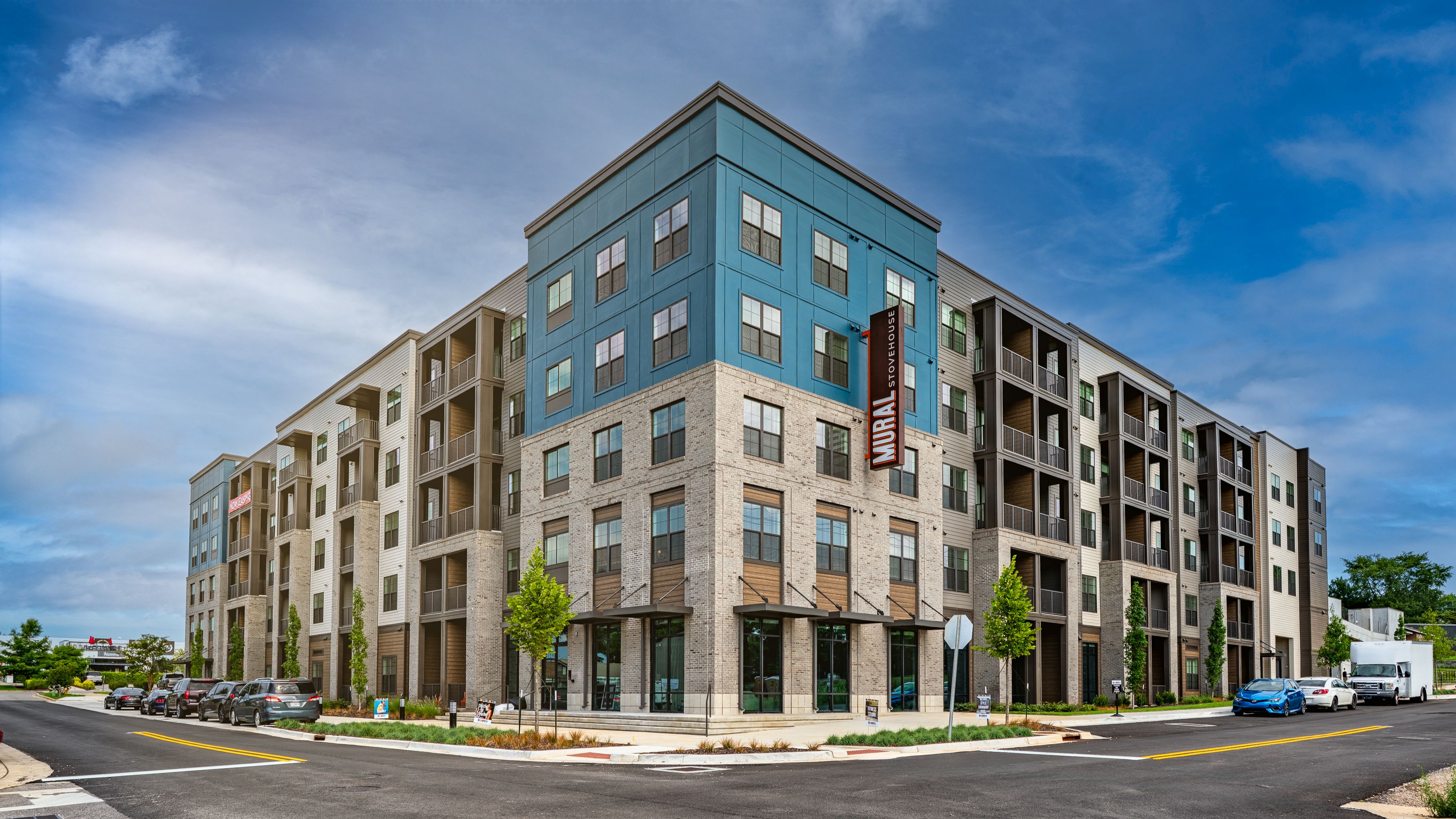 A modern apartment building with a mix of blue and beige balconies.