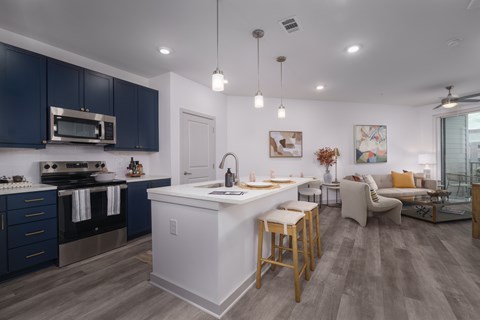 A modern kitchen with dark blue cabinets and a white island.