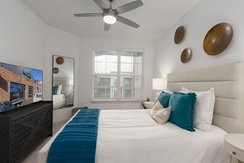 A bedroom with a large bed and a flat screen TV.