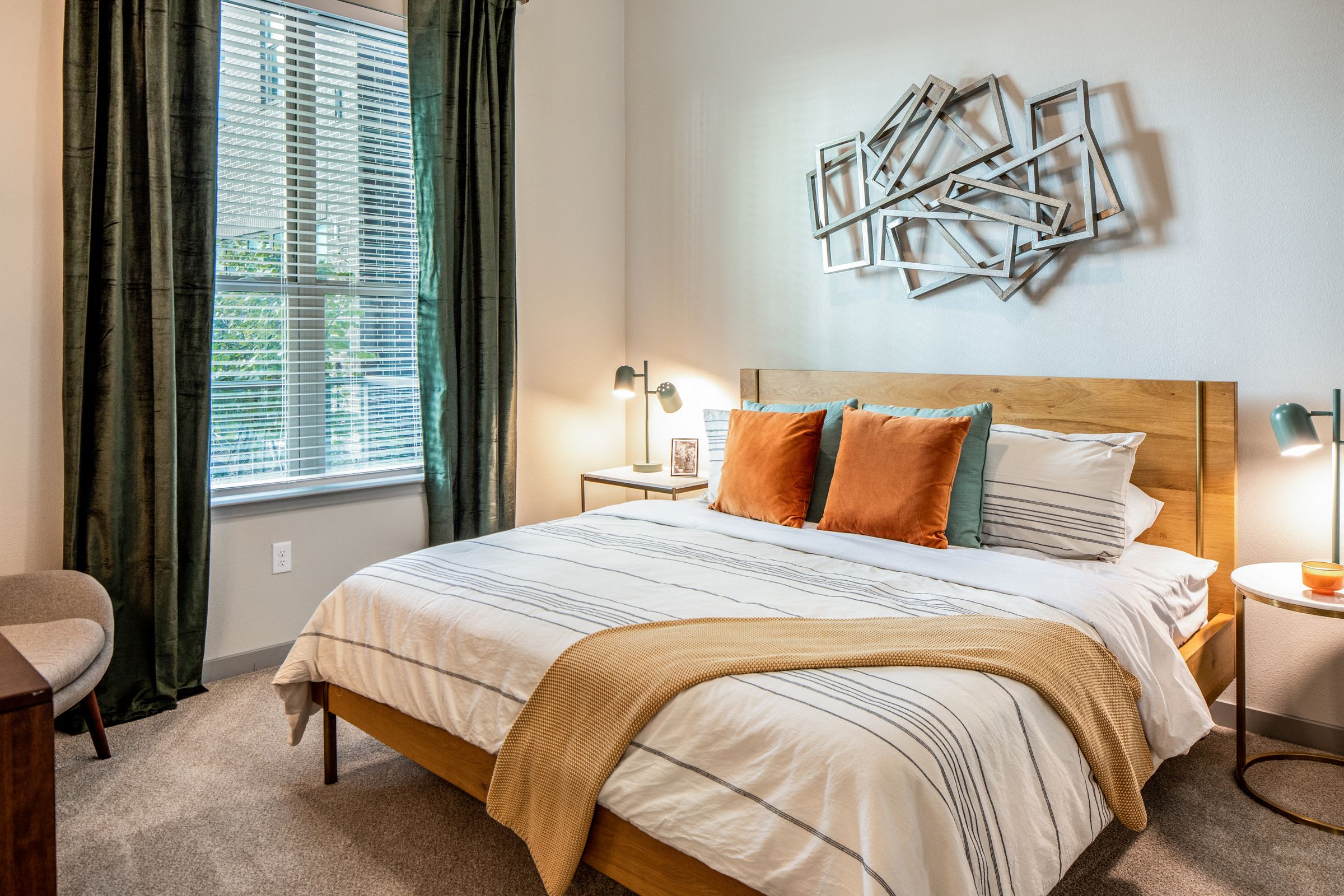 A bedroom with a large bed and a chair.