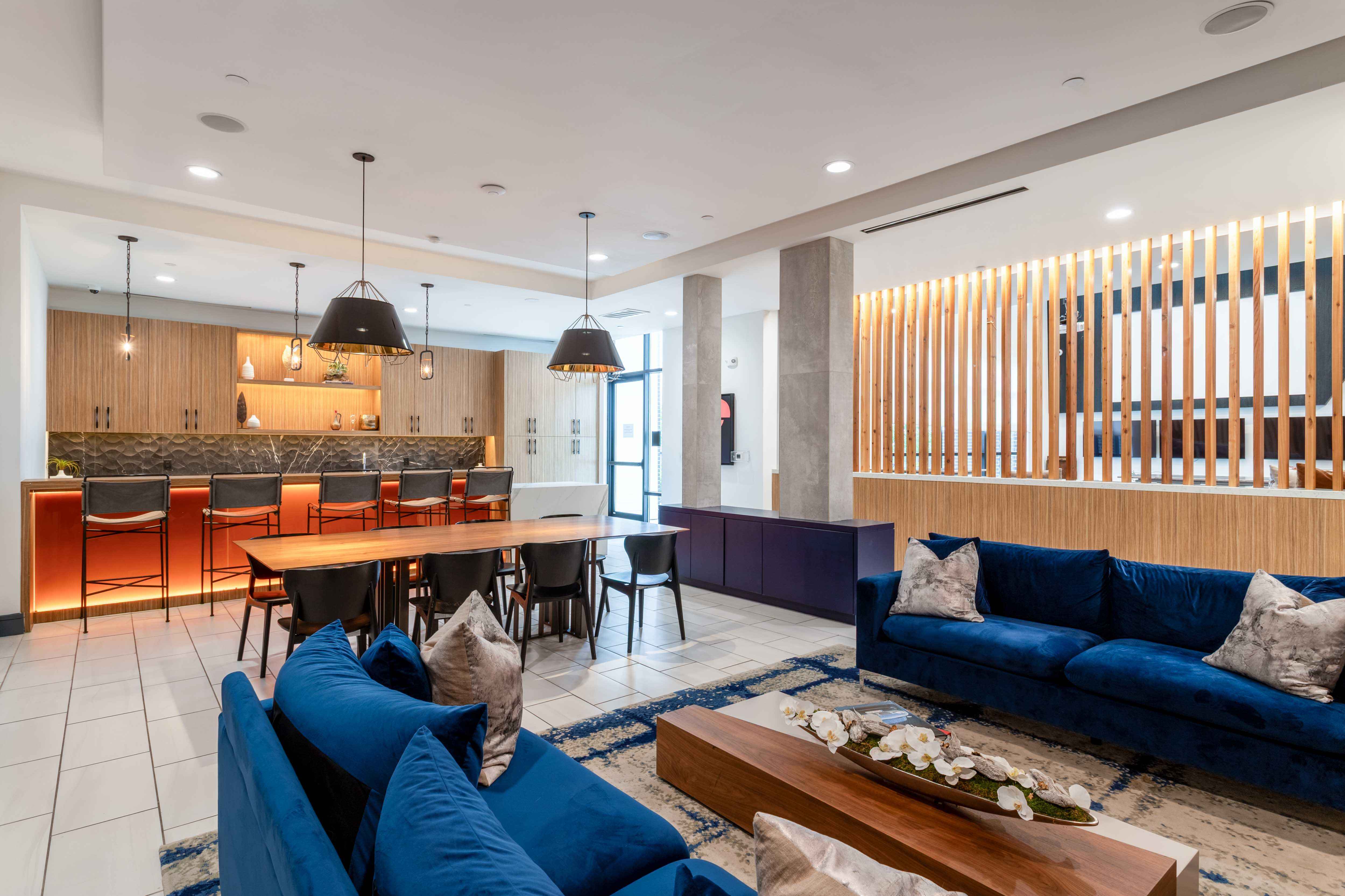 A modern living room with a blue sofa and wooden accents.